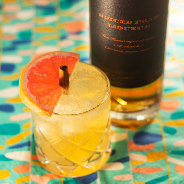 vibrantly colored tablecloth wit a little cocktail garnished with grapefruit