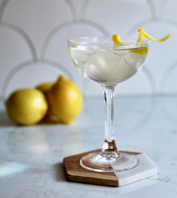 Scalloped white tile behind a lemony looking martini